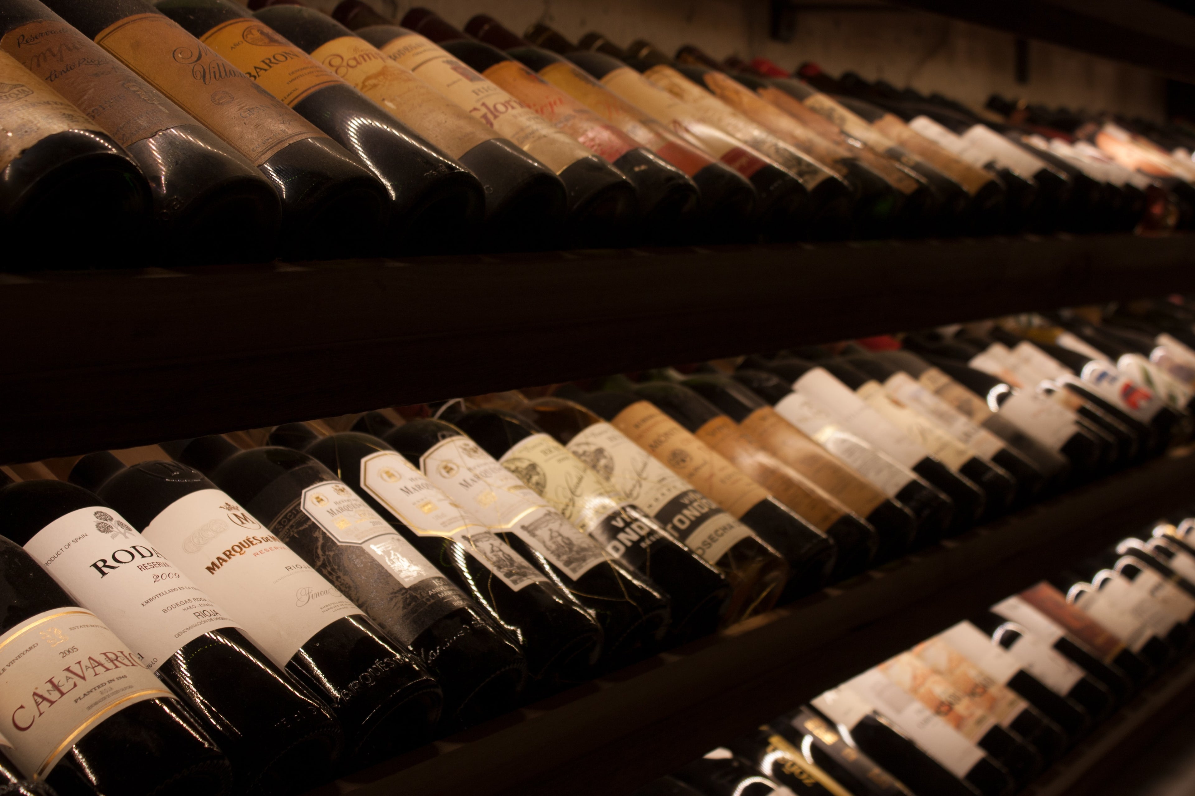 Weinregal mit liegenden Flaschen Weinankauf Maniola wines
