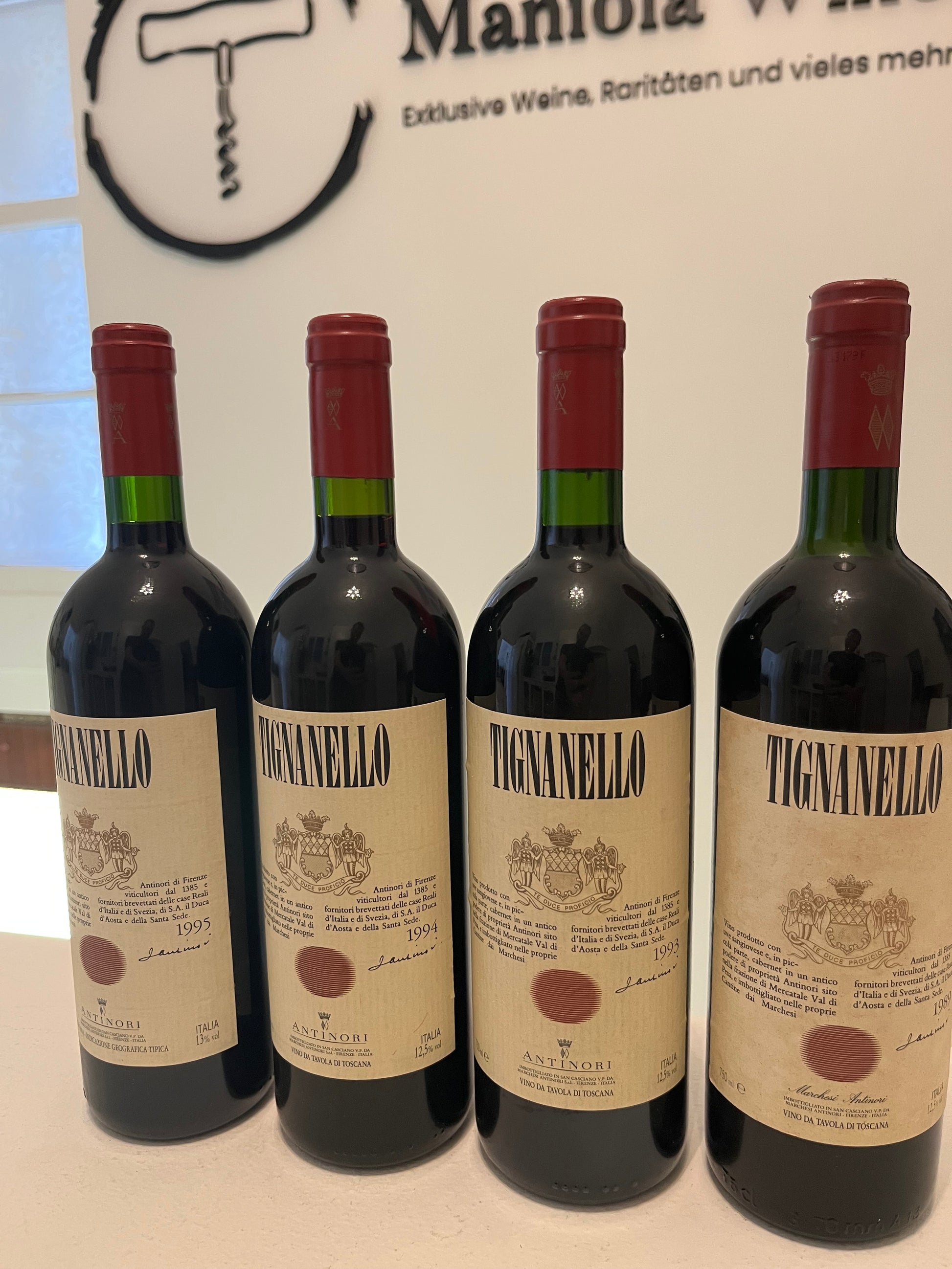4 Flaschen Tignanello mit Maniola Wines Logo im Hintergrund