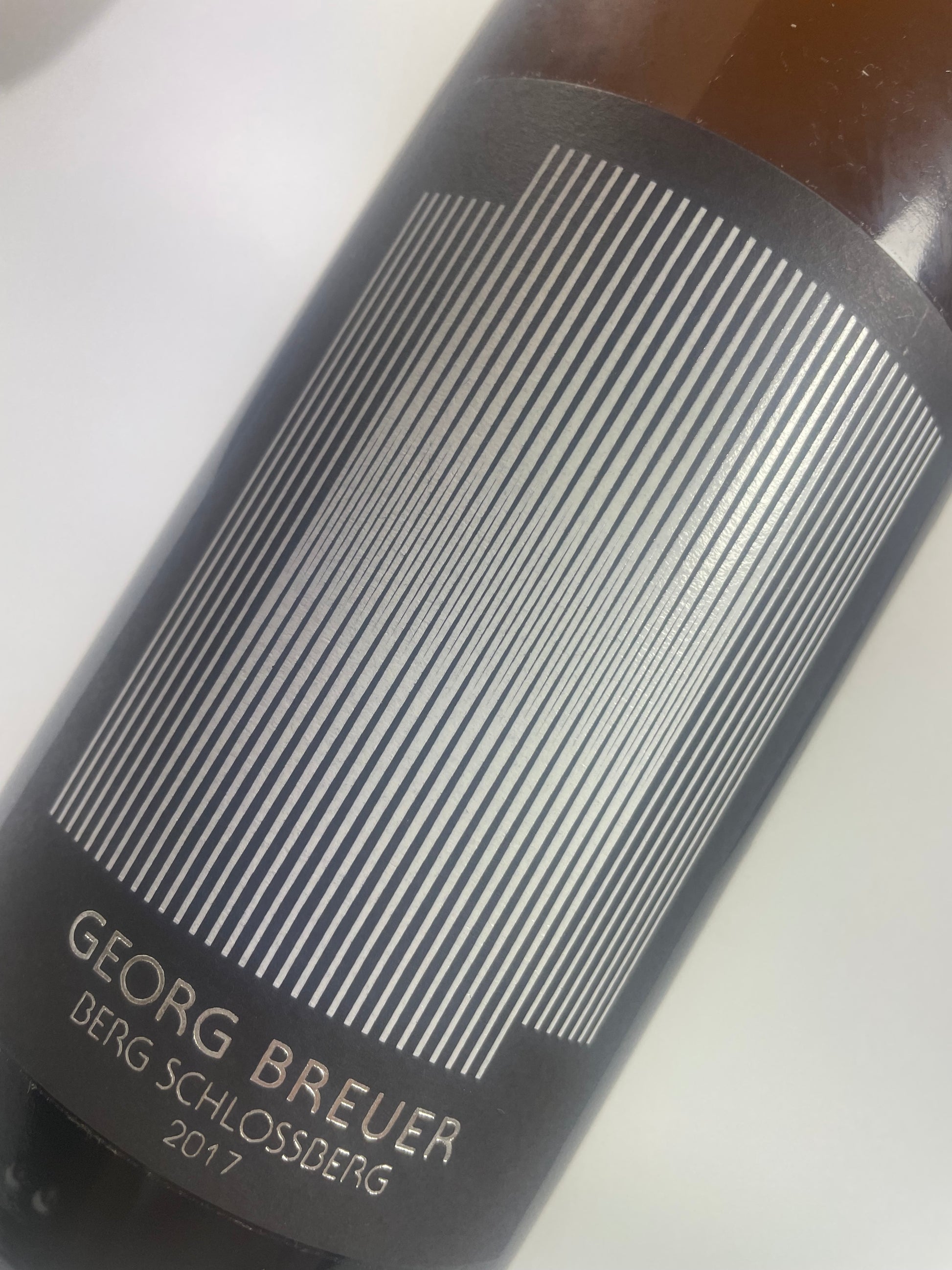 Flasche mit kunstvollem Etikett: „Schlossberg Riesling 2017 Flasche, frontaler Ausschnitt, Etikett ist Mittelpunkt – edel, klar strukturiert, Name und Vintage stehen im Fokus